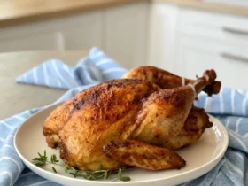 Crispy and golden Air Fryer Half Chicken on a plate with fresh herbs.